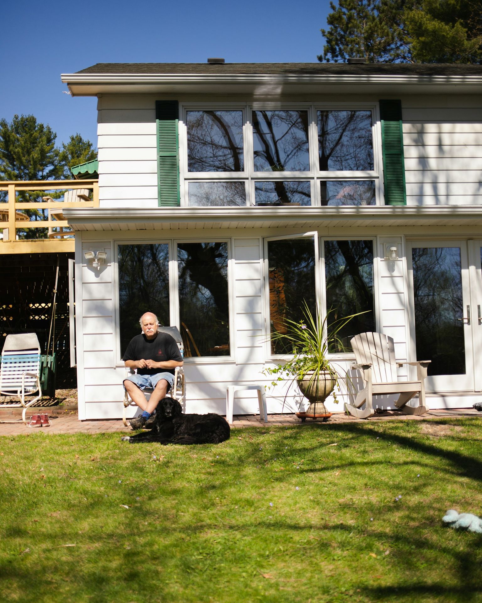 a person sitting on a lawn chair in front of a house